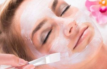 smiling woman applies chemical peels to face
