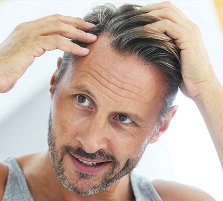 man checking his hair after Micro Needling Treatment for Scalp Hair Growth