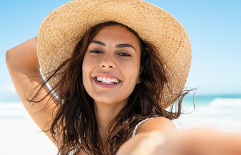 cheerful girl on the beach holds a hat on head Atlanta, GA