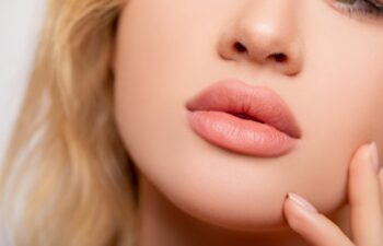 Beautiful lips Close-up. Makeup. Lip matte lipstick. Sexy lips. Part of face, young woman close up. perfect plump lips bodily lipstick. peach color of lipstick on large lips. Perfect makeup
